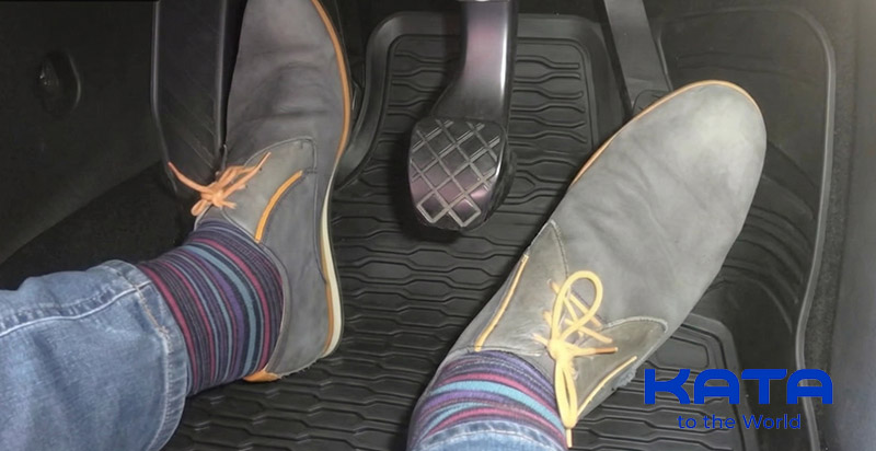 Checking the clearance between the car floor mat and the gas and brake pedals.