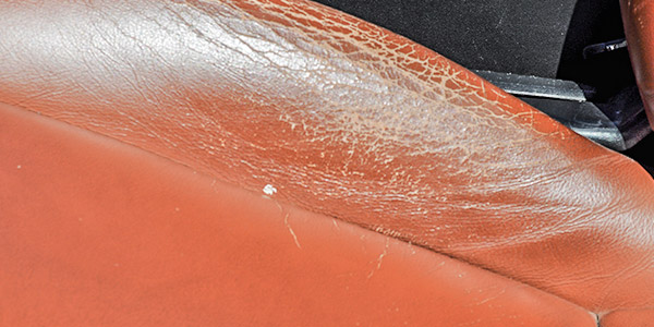 Cracked leather car seats needing repair due to UV exposure and wear.